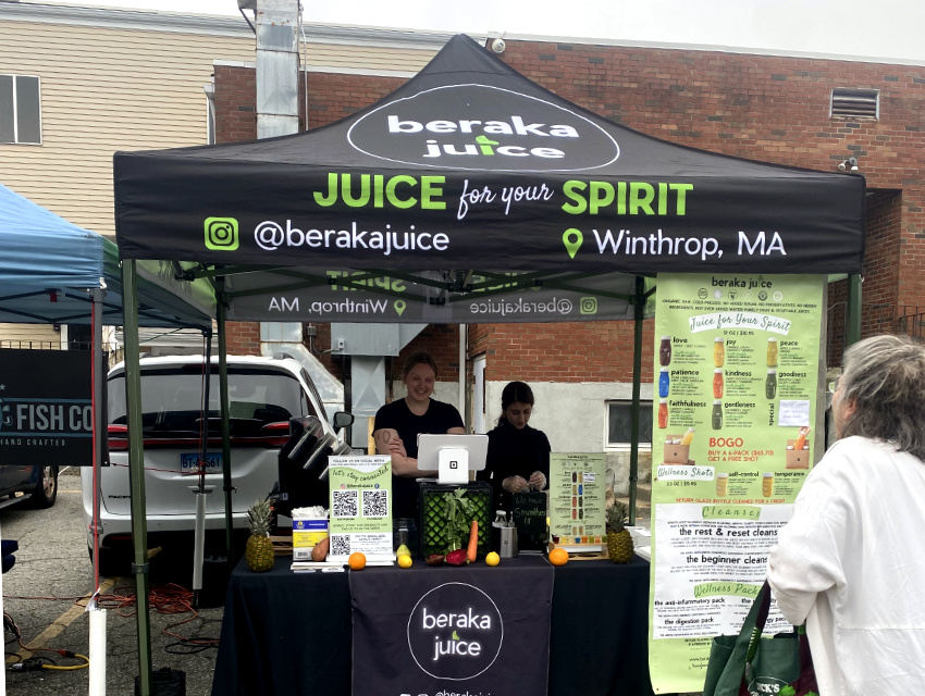 Beraka Juice Classic Pro setup with a custom canopy and branded table runner at an outdoor event