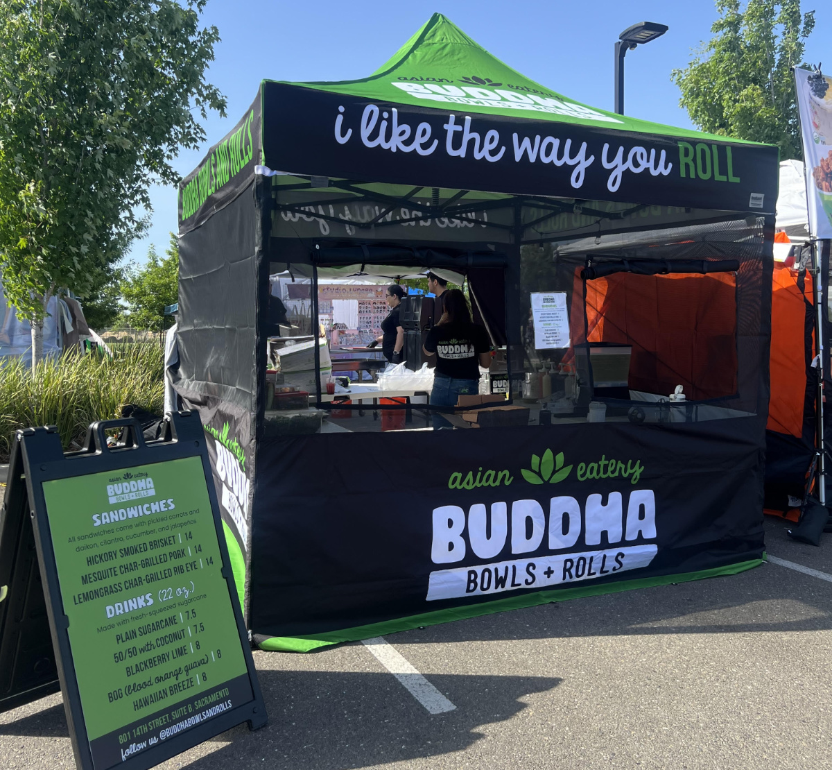 Green and black custom canopy tent for Buddha Bowls + Rolls with full branded front panel and menu signage.