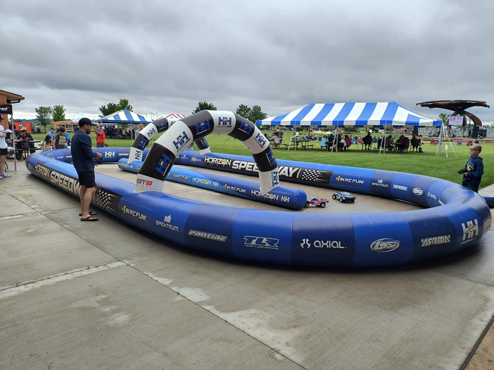 Branded inflatable race track for events with continuous barrier walls and archways
