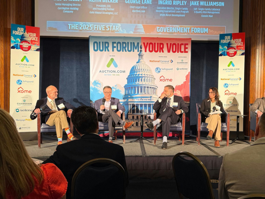 Stage panel event using a large trade show backdrop banner behind speakers, repurposed to brand a forum setting