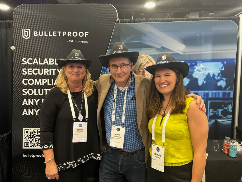 Bulletproof team standing in front of portable trade show displays and 10x10 trade show booth backdrop