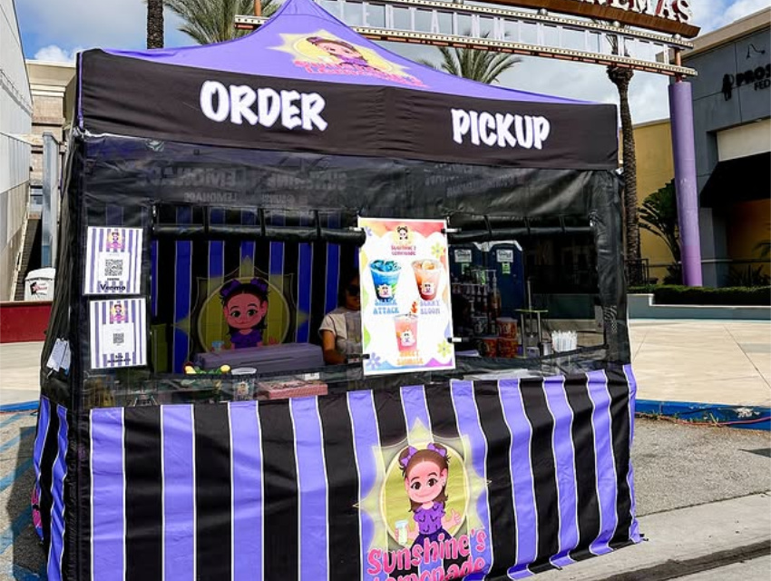 Sunshine’s Lemonade custom food vendor tent with purple and black canopy labeled Order and Pickup